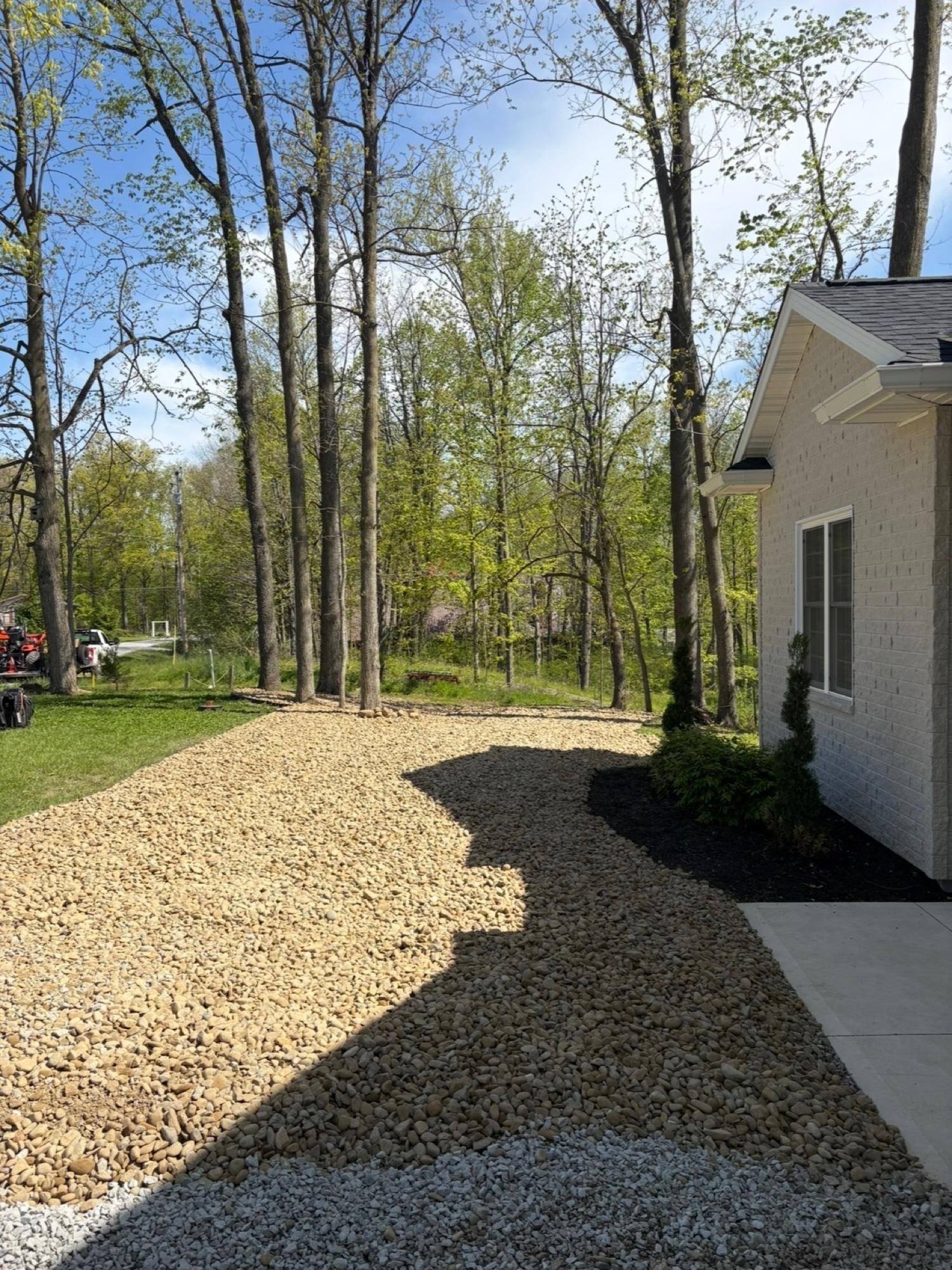 Freshly installed decorative stone walkway and planting bed alongside a home